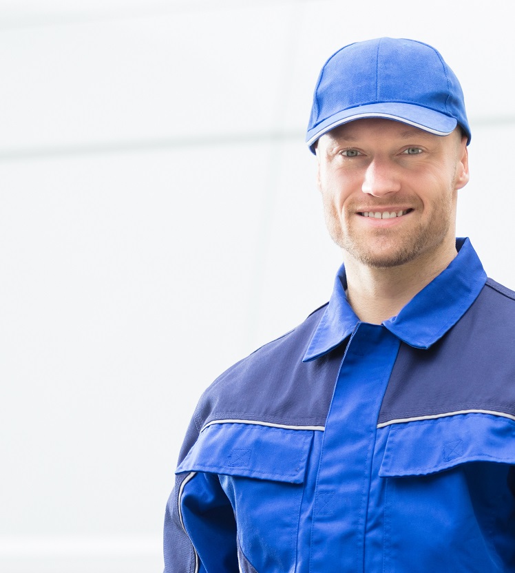 Ein Elektriker im Blaumann lächelt in die Kamera.