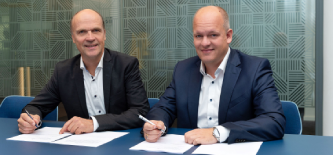 Foto von Peter Flosbach, Technischer Geschäftsführer bei DEW21, und Dominik Serfling, Leiter Stadtentwicklungsprojekte bei DSW21, die am Tisch sitzend Verträge unterzeichnen