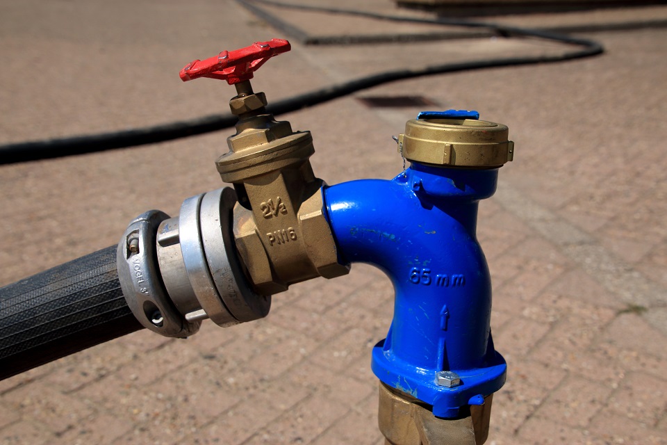 Blaues Rohr mit rotem Ventilgriff, Text '65 mm' und '2½ PN16' sichtbar.