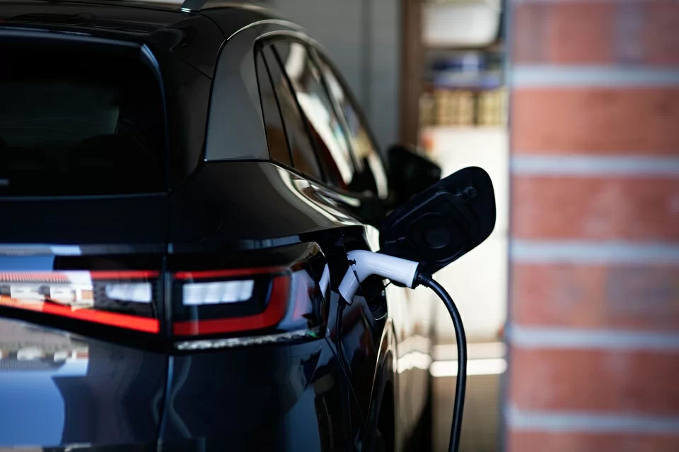 Elektrofahrzeug wird in einer Garage geladen, Kabel am Ladeanschluss hinten rechts.