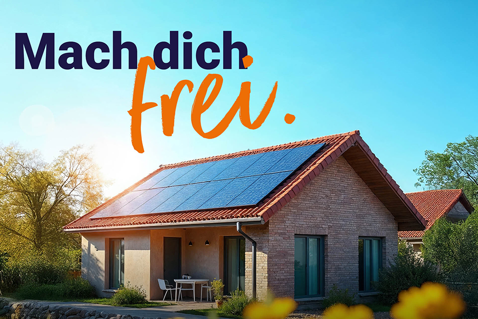 Modernes Haus mit Solarpanels auf dem Dach, umgeben von Grünflächen, blauer Himmel im Hintergrund.
