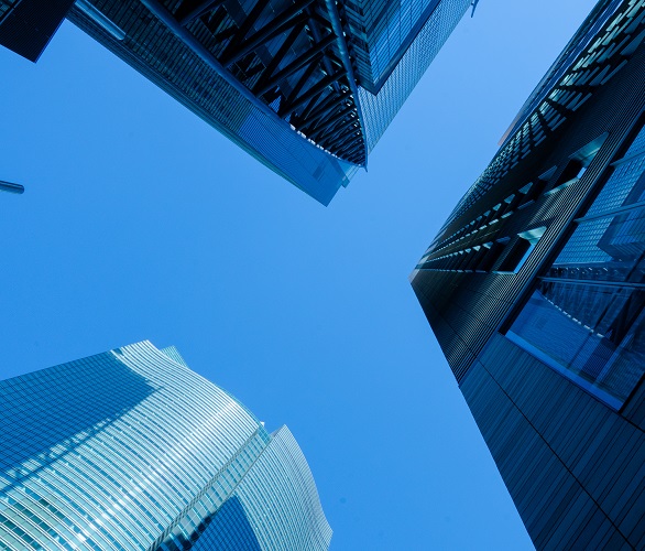 Moderne Wolkenkratzer mit Glas- und Stahlfassaden vor klarem Himmel.