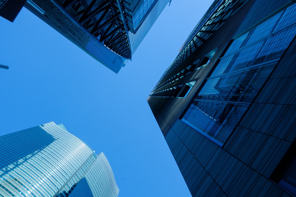 Moderne Wolkenkratzer mit Glas- und Stahlfassaden vor klarem Himmel.