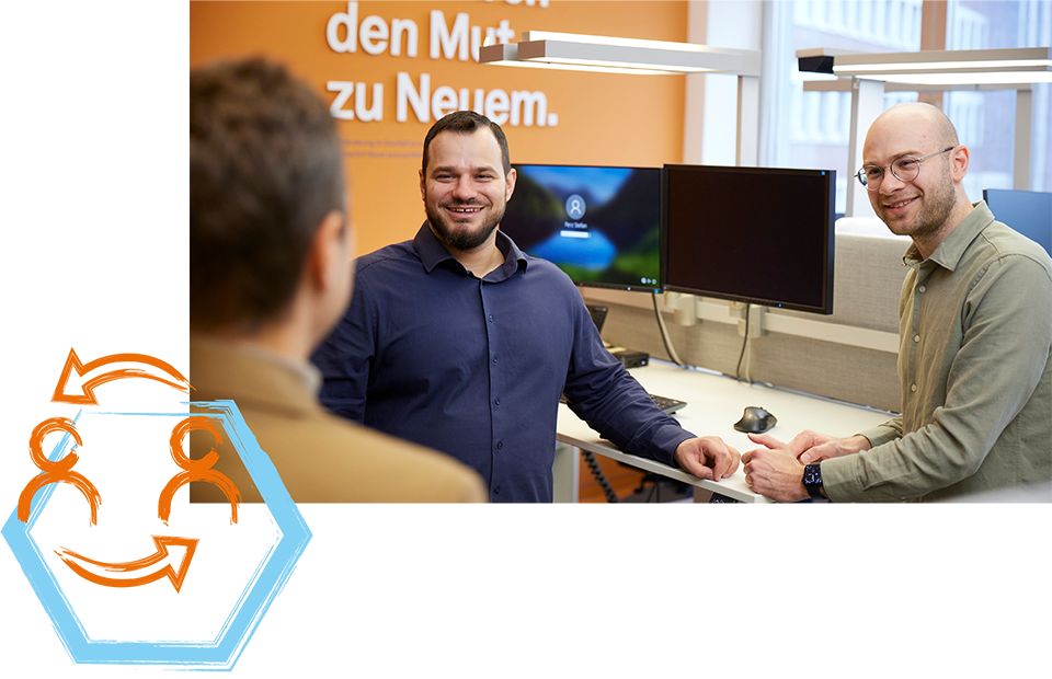 Drei Personen im Büro, zwei stehen an einem Schreibtisch mit Monitoren, eine Person ihnen zugewandt, Text 'den Mut zu Neuem' an der Wand, Illustration von zwei Figuren mit Pfeilen links im Bild.