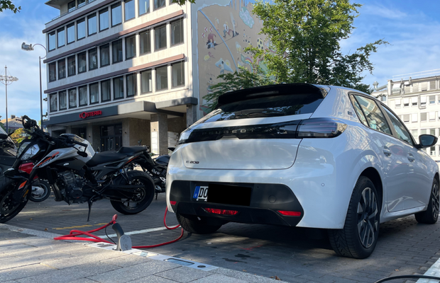 E-Auto welches in einem Ladebordstein an der straße angeschlossen ist