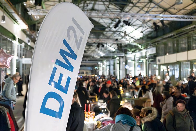 Menschenmenge bei einer Indoor-Veranstaltung mit DEW21-Flagge im Vordergrund