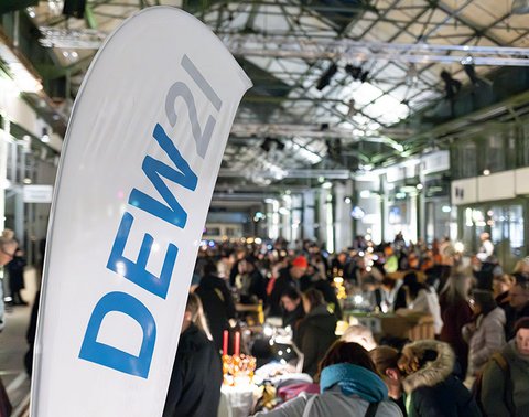 Menschenmenge bei einer Indoor-Veranstaltung mit DEW21-Flagge im Vordergrund