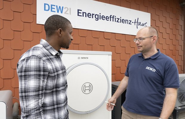 Ein Kunde wird vor dem Energieeffizienz-Haus beraten.
