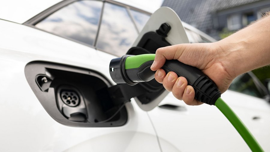 E-auto das gerade mit dem Ladekabel verbunden wird