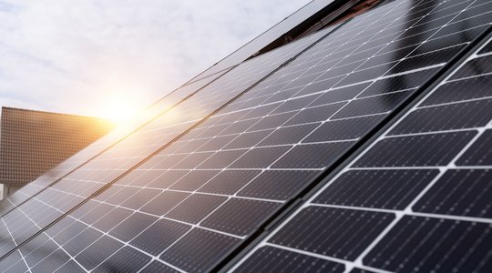 Photovoltaikanlage mit der Sonne im Hintergrund 