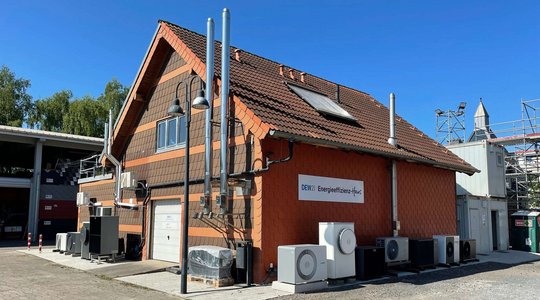Energieeffizienz-Haus DEW21 mit Technik und Klimageräten vor blauem Himmel