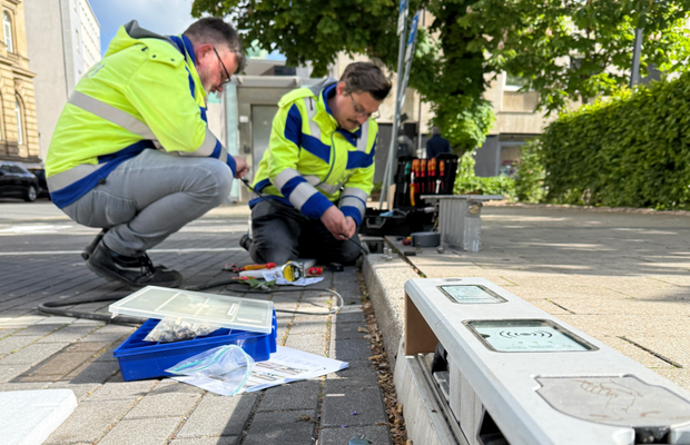 Zwei Männer die einen ladebordstein an einer Straße installieren