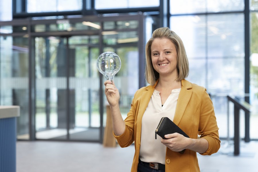 Eine Frau hält eine Glühbirne in der Hand