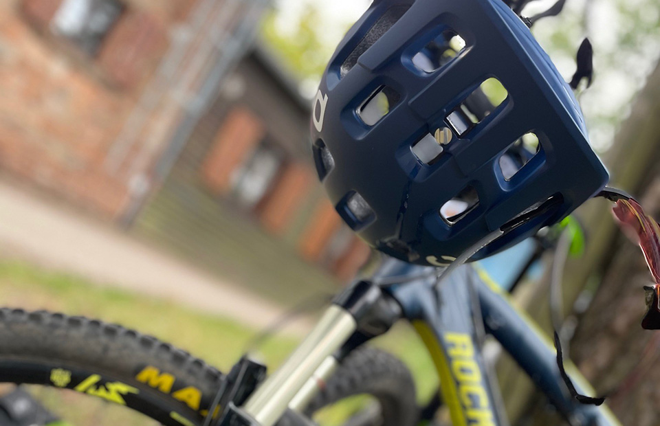 Eine Nahaufnahme eines Mountainbikes an dem ein Fahrradhelm hängt.